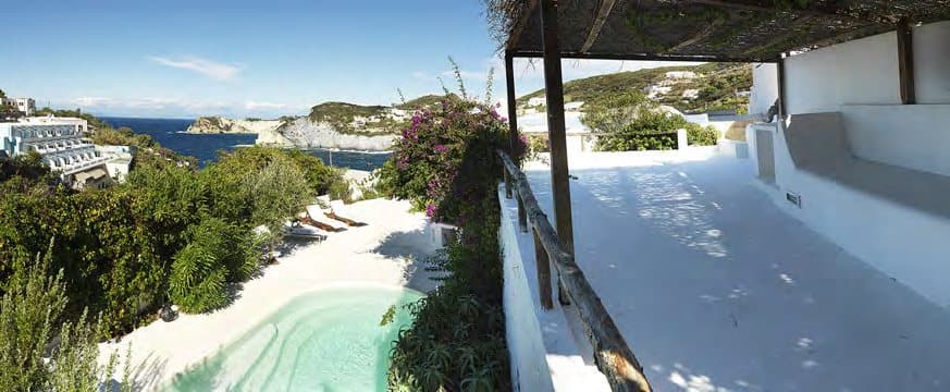 Whitewashed paths lead from the pool towards the sea.
