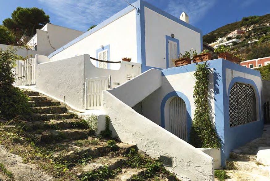Island architecture: white walls, blue trim and garden steps.