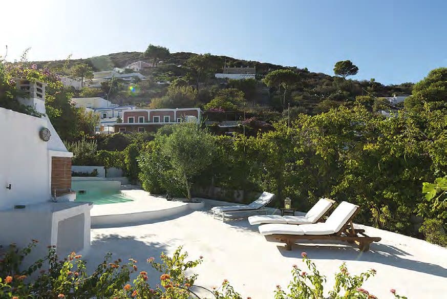 Sun loungers above the pool, among flowering terraces.