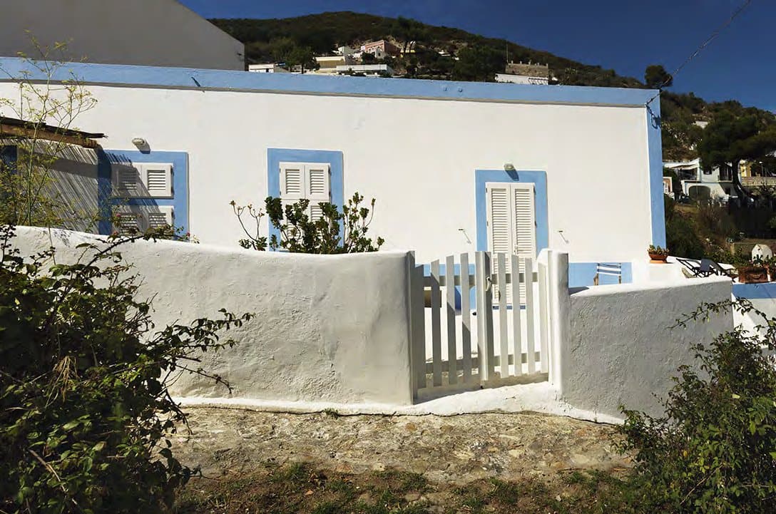 The main house, its blue French doors opening onto the terraces.