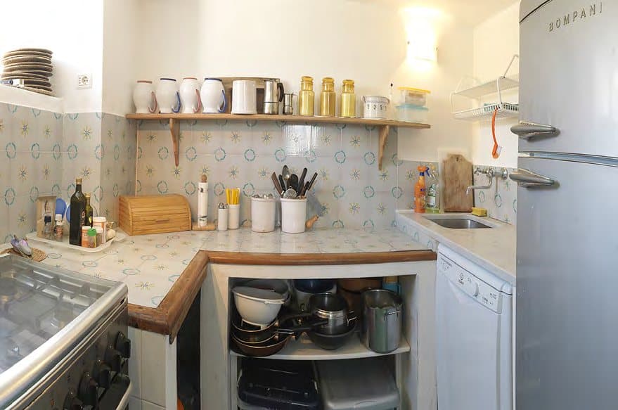 A fully equipped kitchen with oven, fridge and dishwasher.